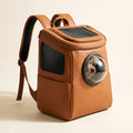 Tan leather pet carrier backpack with bubble window and mesh ventilation, padded straps