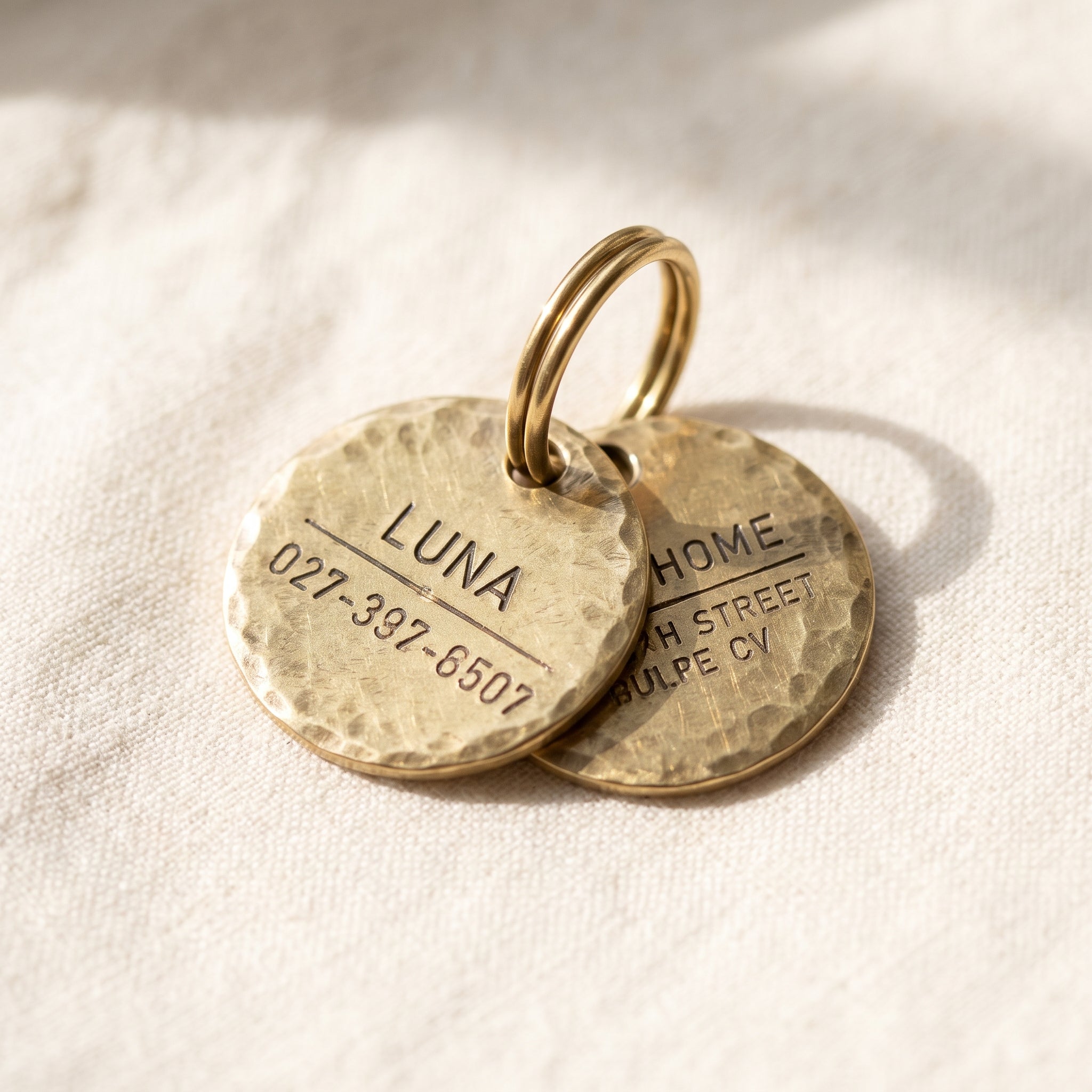 Tiny brass round ID tag for cats, hand-hammered texture, engraved on both sides