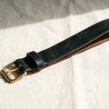 Hand-tanned onyx black leather dog collar with brass hardware, minimalist Nordic style