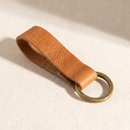 Tan vegetable-tanned leather keychain with solid brass split ring, minimalist design